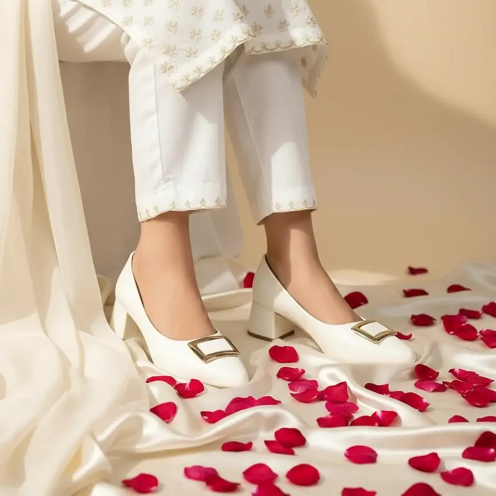 White block heel pumps with gold buckle worn by Pakistani woman in white shalwar kameez — PumpItUp